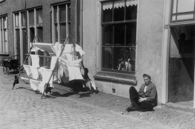 221144 Afbeelding van een wasrek en een jongeman bij (vermoedelijk) het huis Oranjestraat 53 te Utrecht.